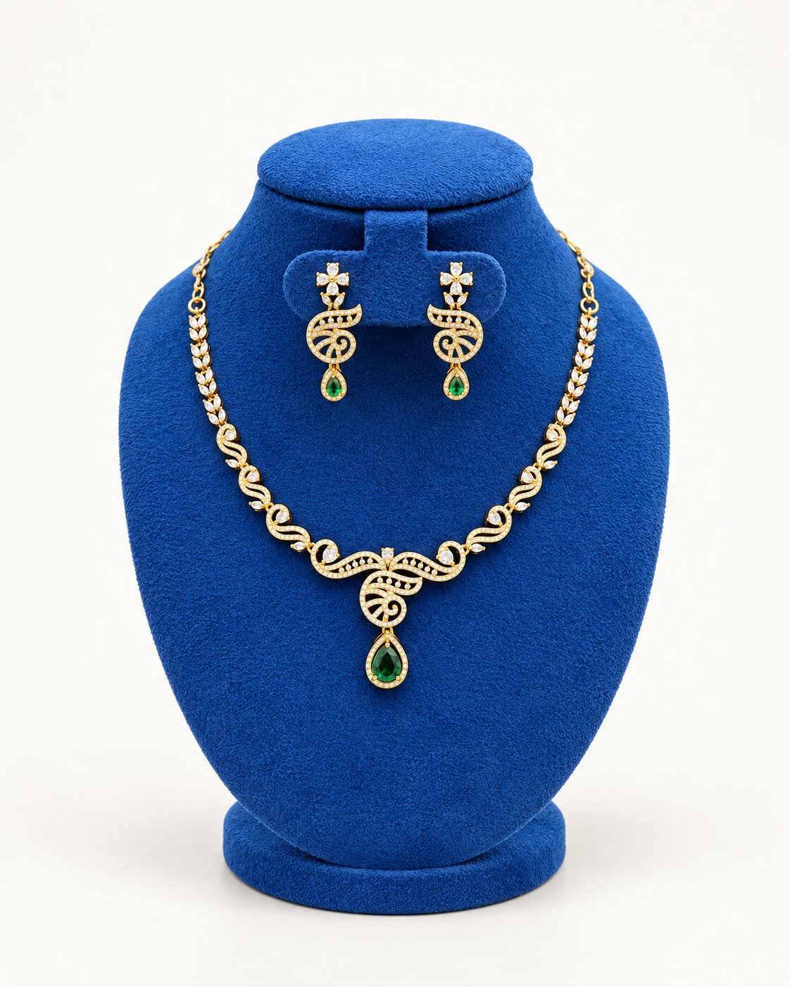 Kaveri swirl leaf pendant necklace set with earrings in green on a blue velvet display stand