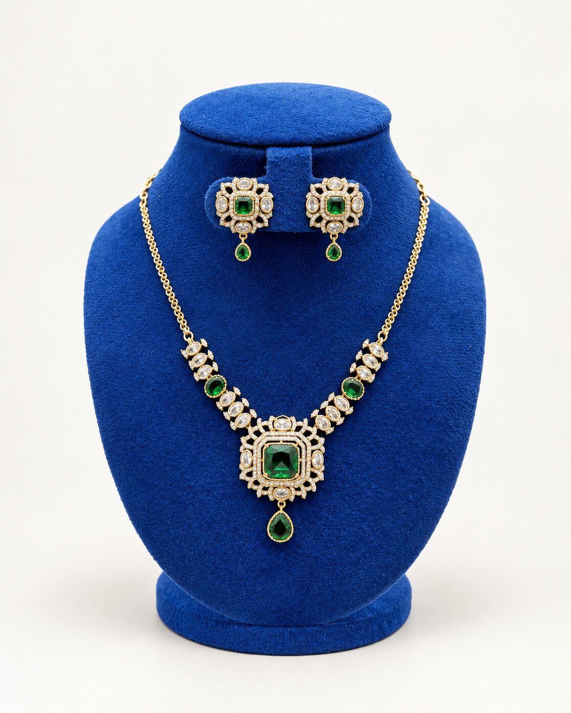 Kaveri square sunburst pendant necklace set with earrings in green on a blue velvet display stand