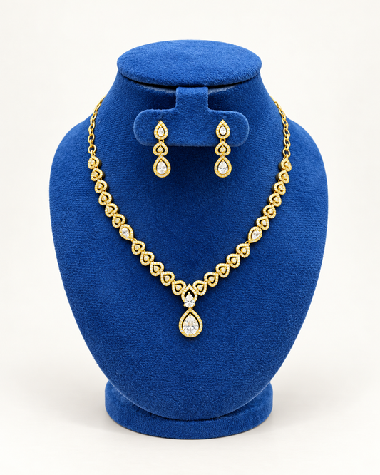 Kaveri heart garland teardrop necklace set with earrings in clear on a blue velvet display stand