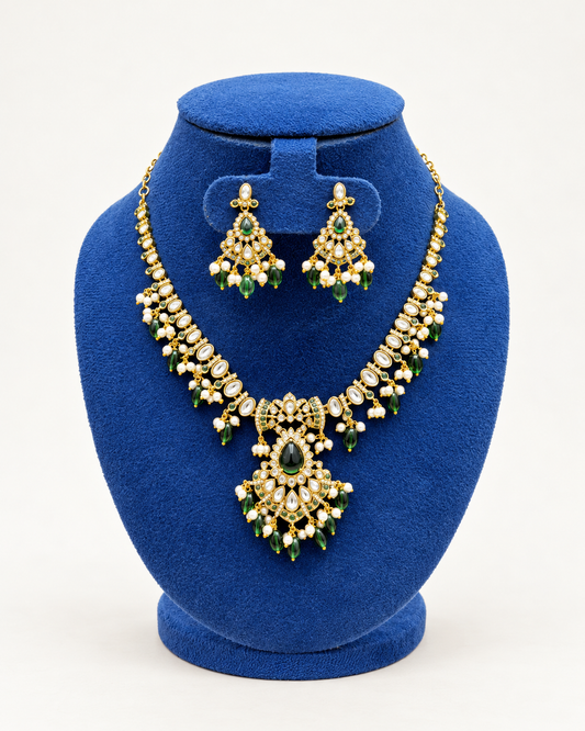 Kaveri kundan style beaded necklace set with earrings in green on a blue velvet display stand