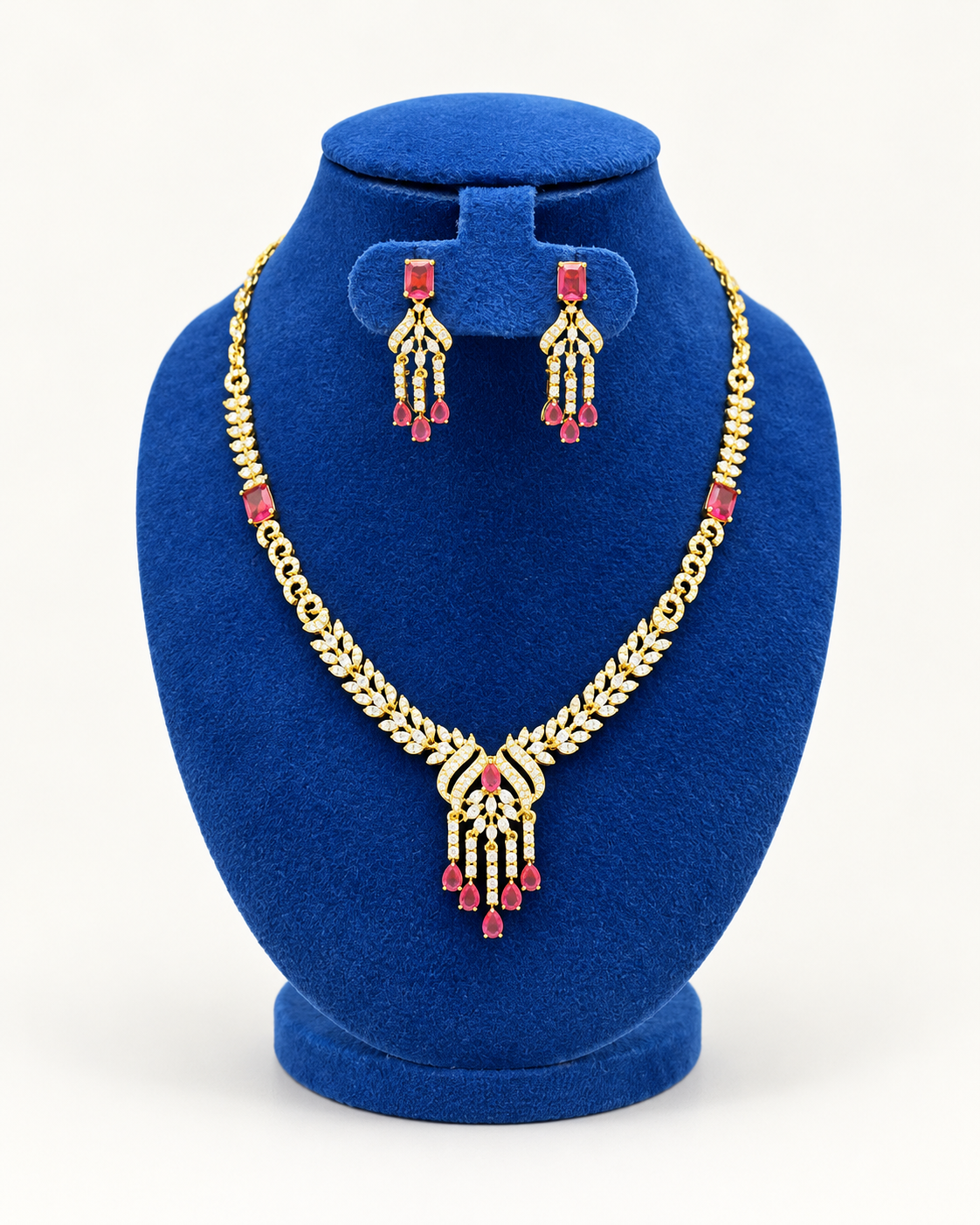 Kaveri leaf fan tassel necklace set with earrings in maroon on a blue velvet display stand