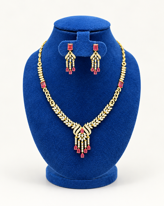 Kaveri leaf fan tassel necklace set with earrings in maroon on a blue velvet display stand