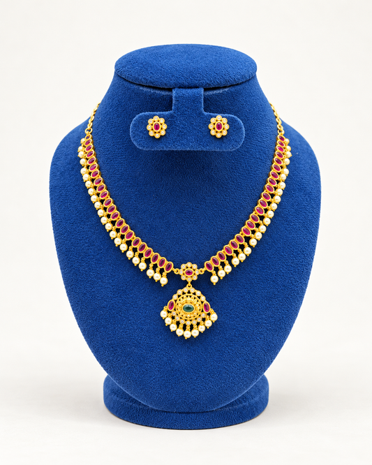 Kaveri twin row stone pendant necklace set with stud earrings in maroon on a blue velvet display stand