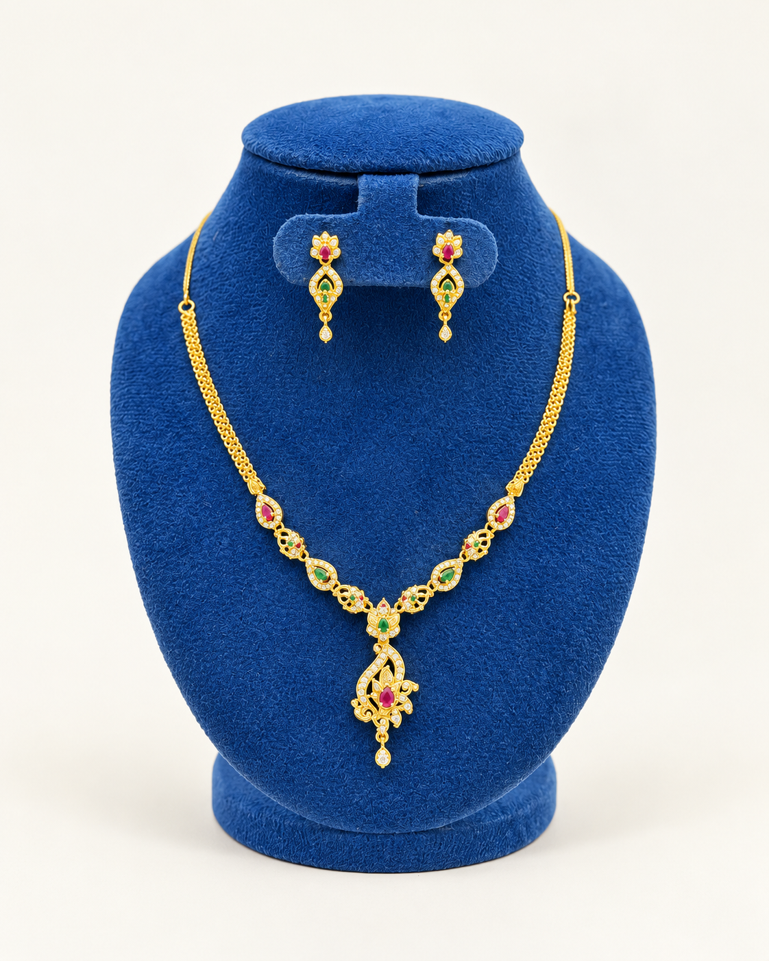 Kaveri paisley pendant stone necklace set with earrings in multicolor on a blue velvet display stand