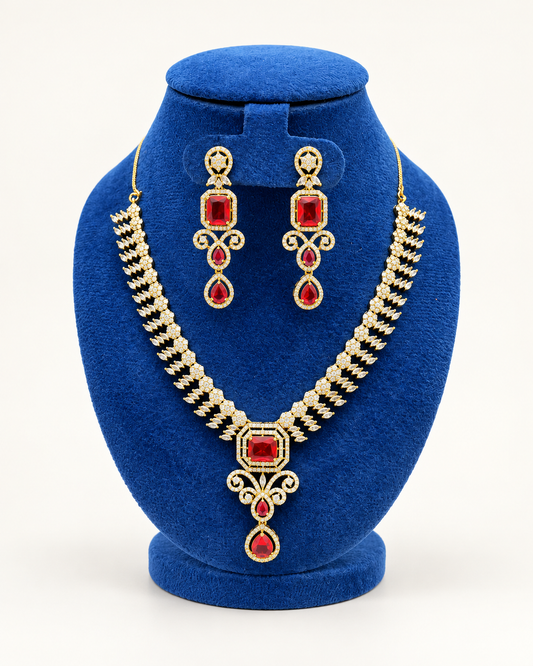 Kaveri rectangular stone cascade necklace set with earrings in maroon on a blue velvet display stand