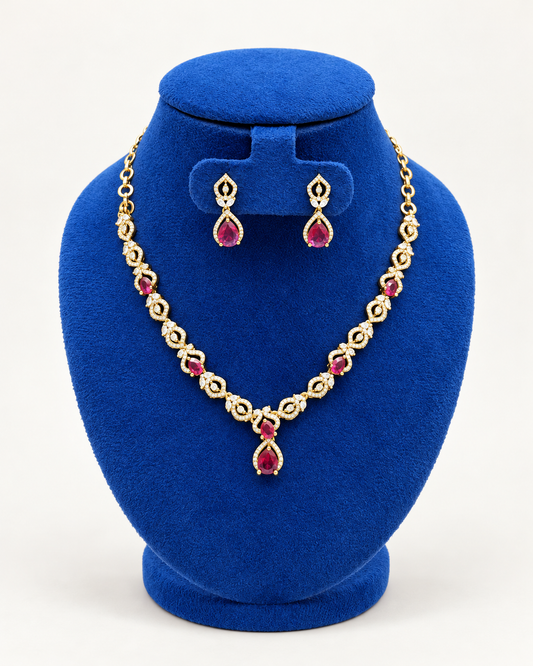 Kaveri double leaf teardrop necklace set with earrings in maroon on a blue velvet display stand