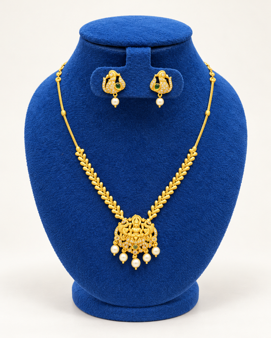 Kaveri temple pendant leaf chain necklace set with earrings in gold on a blue velvet display stand