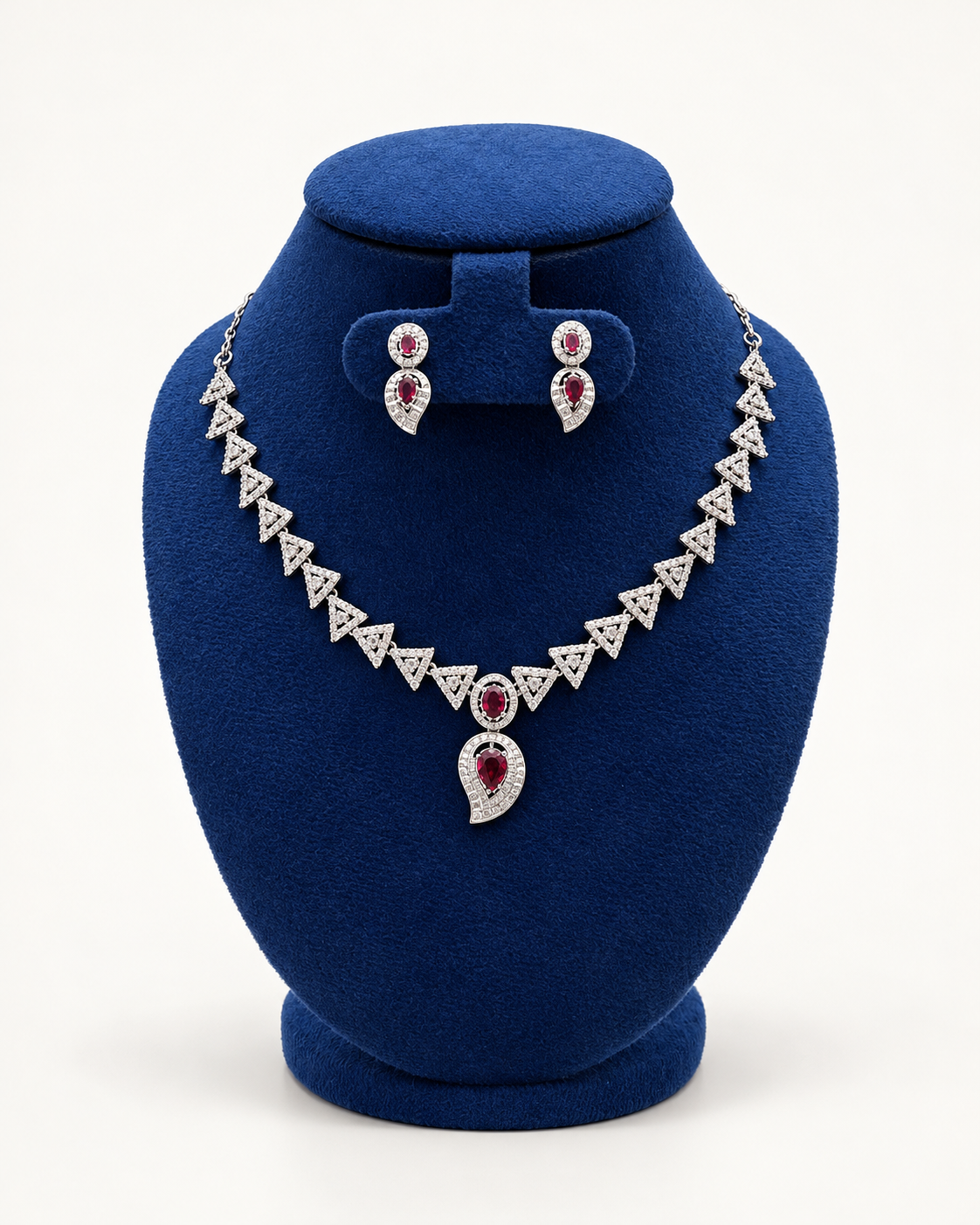 Kaveri triangle link necklace set with drop earrings in maroon on a blue velvet display stand