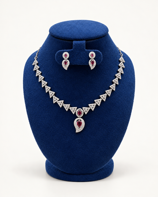 Kaveri triangle link necklace set with drop earrings in maroon on a blue velvet display stand