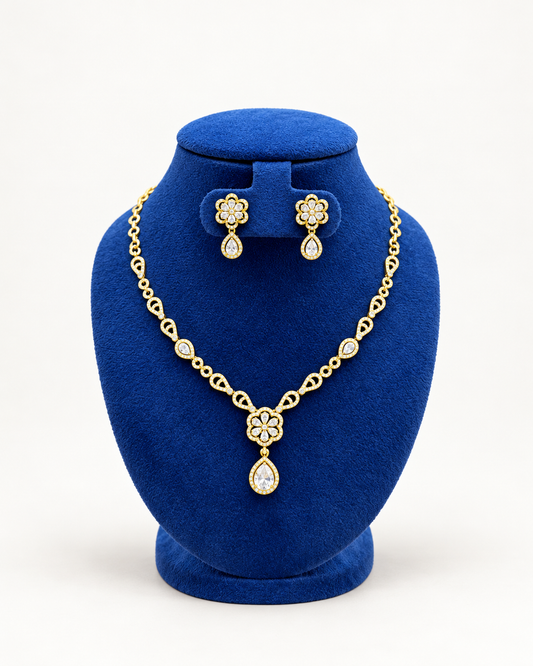 Kaveri floral teardrop pendant necklace set with earrings in clear on a blue velvet display stand