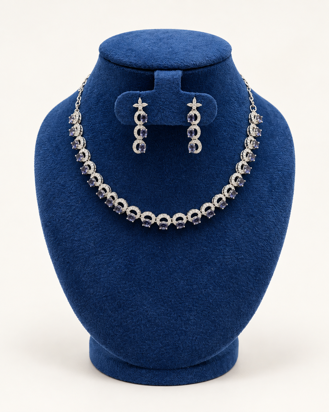 Kaveri crescent link stone necklace set with earrings in blue on a blue velvet display stand