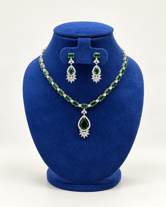 Kaveri oval stone teardrop necklace set with earrings in green on a blue velvet display stand