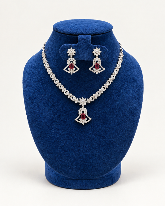 Kaveri fan pendant stone necklace set with earrings in maroon on a blue velvet display stand