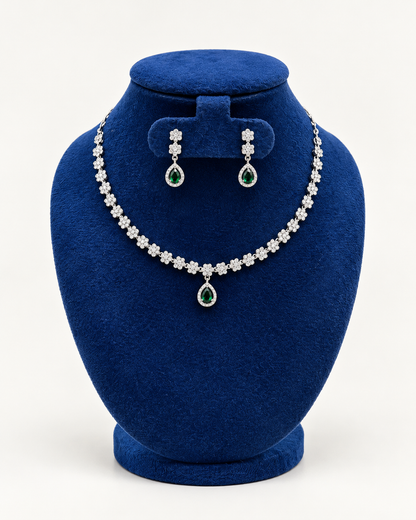 Kaveri flower line teardrop necklace set with earrings in green on a blue velvet display stand