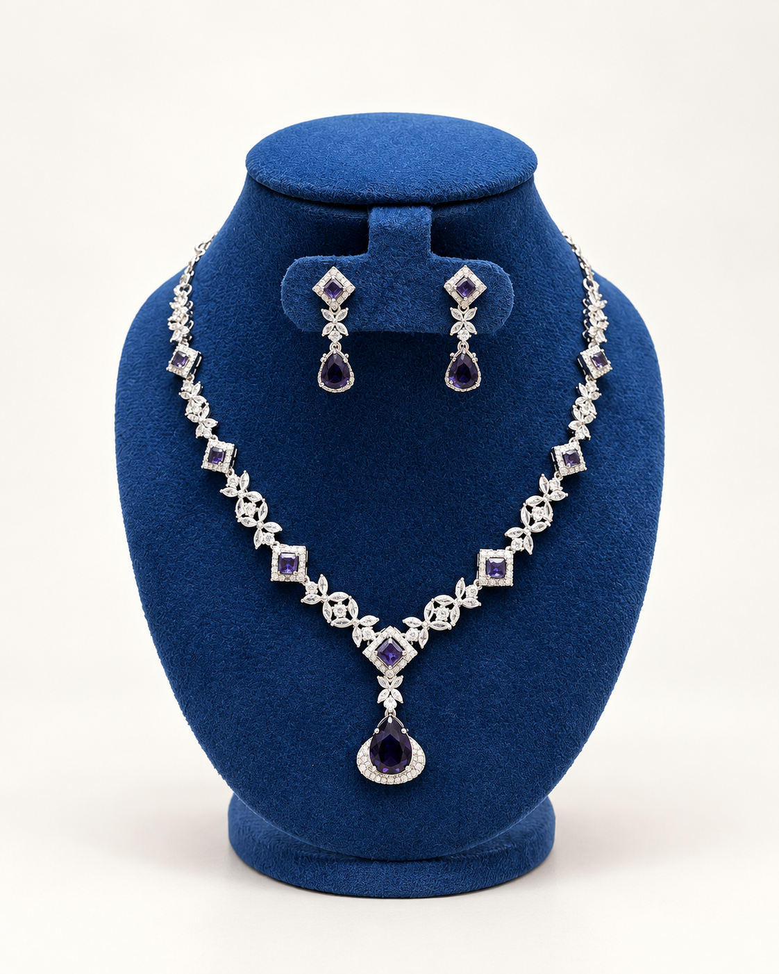 Kaveri square and leaf stone necklace set with earrings in blue on a blue velvet display stand