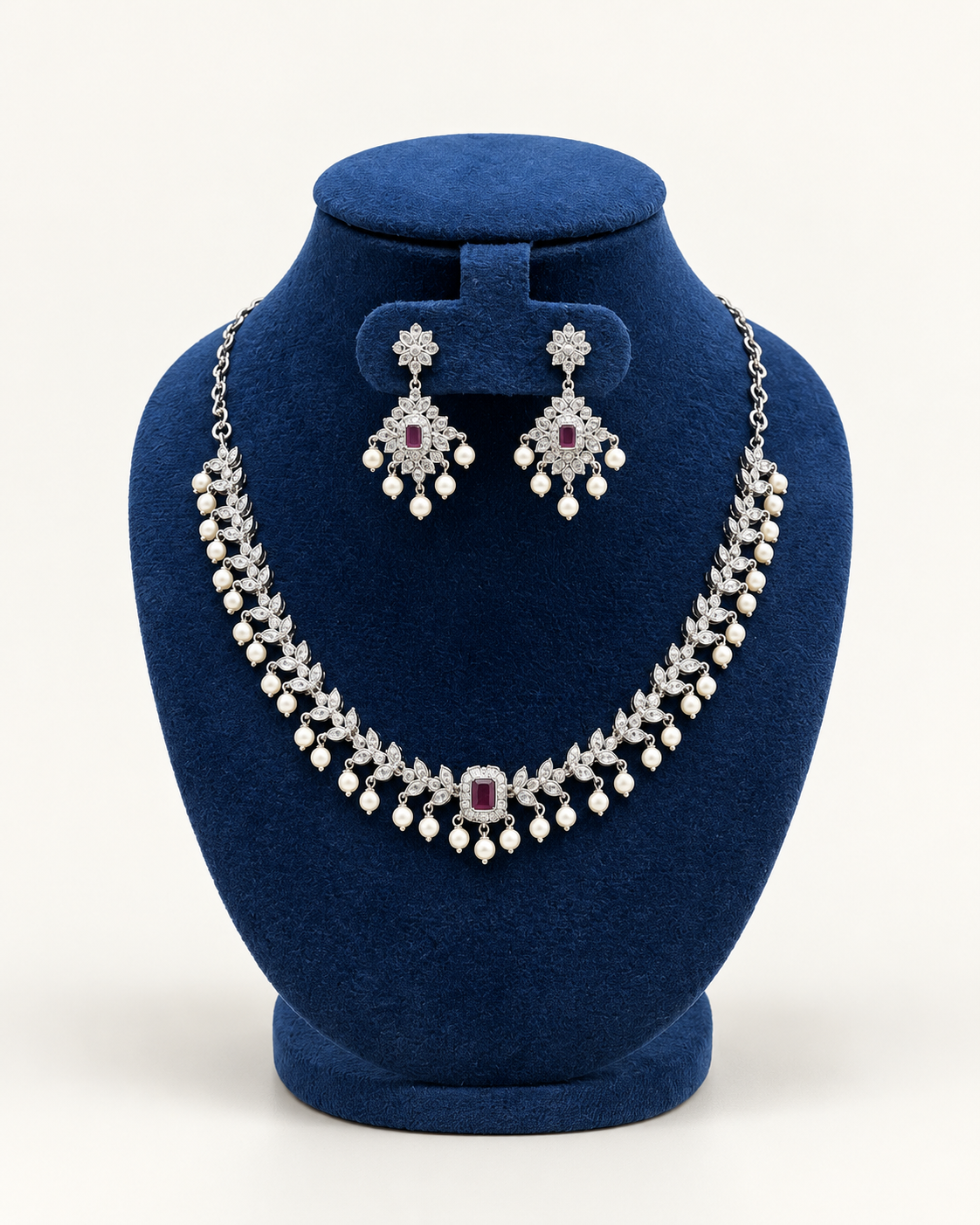 Kaveri double row pearl fringe necklace set with earrings in maroon on a blue velvet display stand
