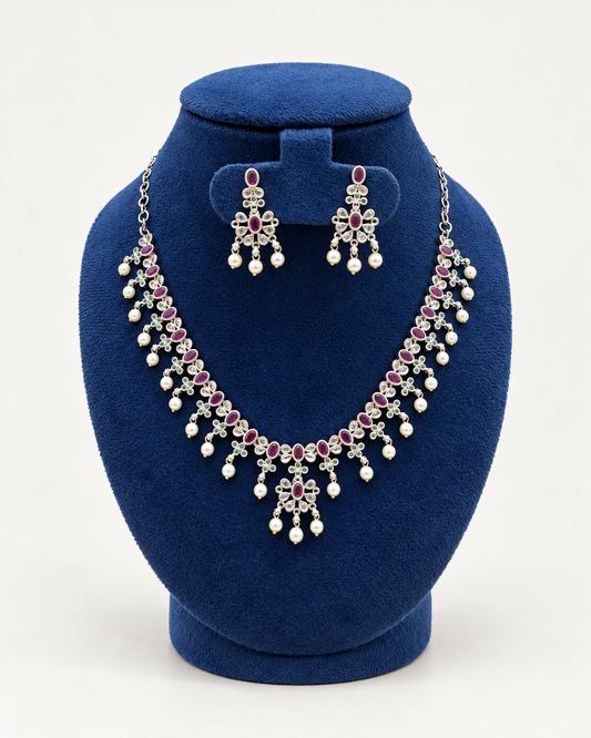Kaveri oval stone pearl fringe necklace set with earrings in pink on a blue velvet display stand