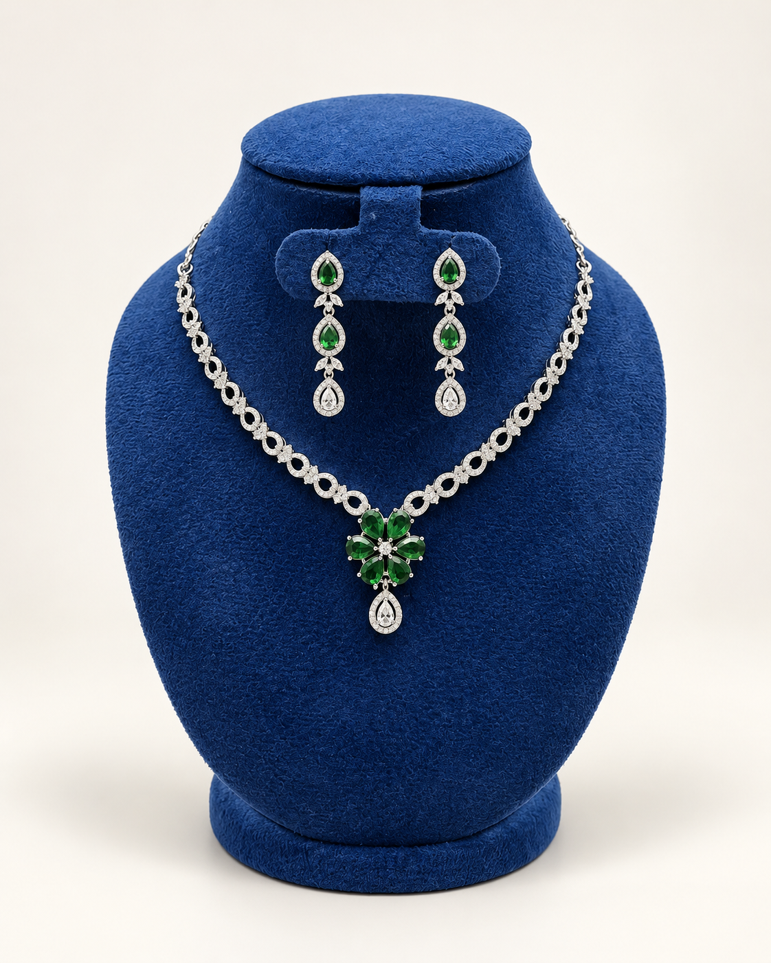 Kaveri floral centre necklace set with drop earrings in green on a blue velvet display stand