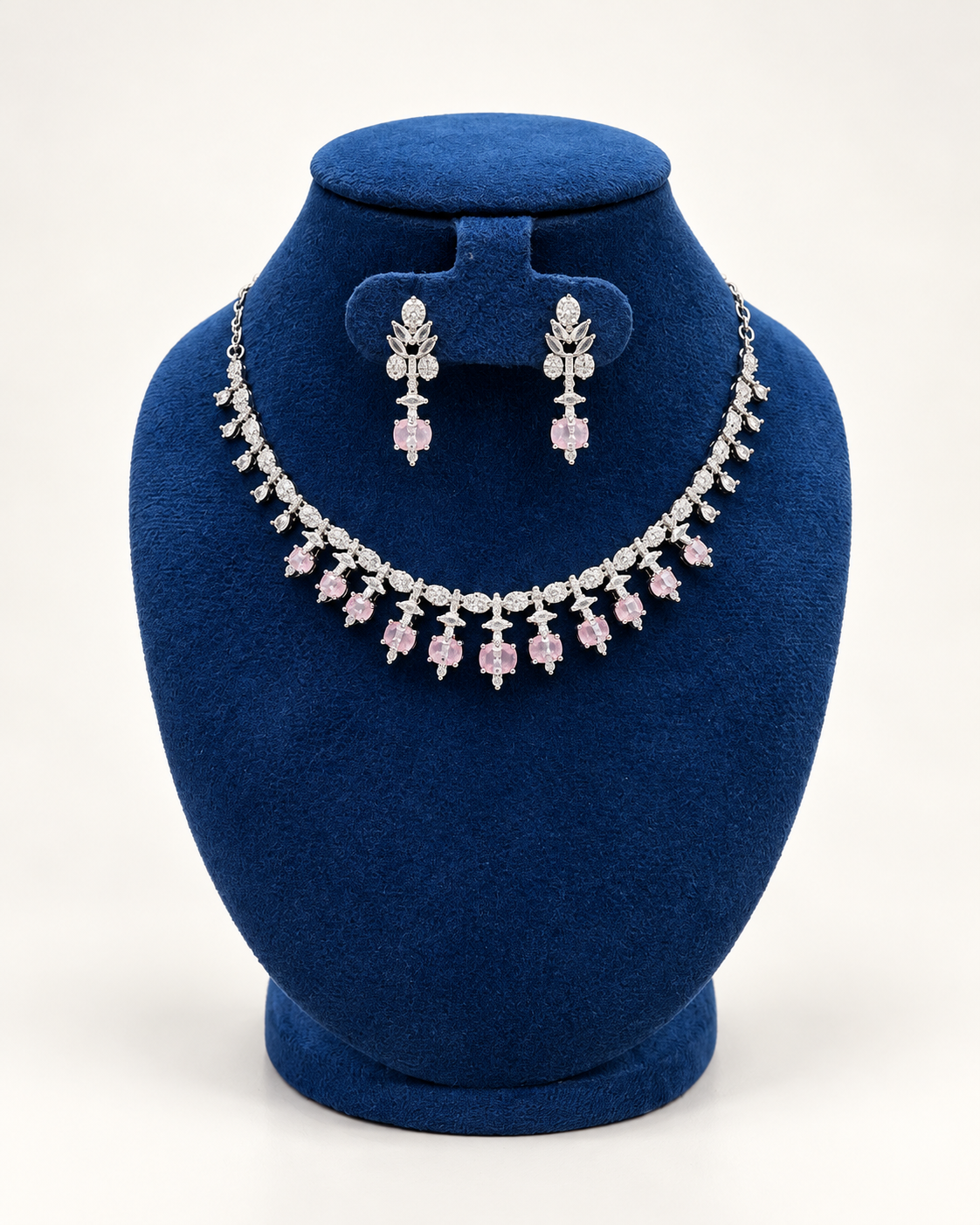 Kaveri floral fringe necklace set with earrings in pink on a blue velvet display stand