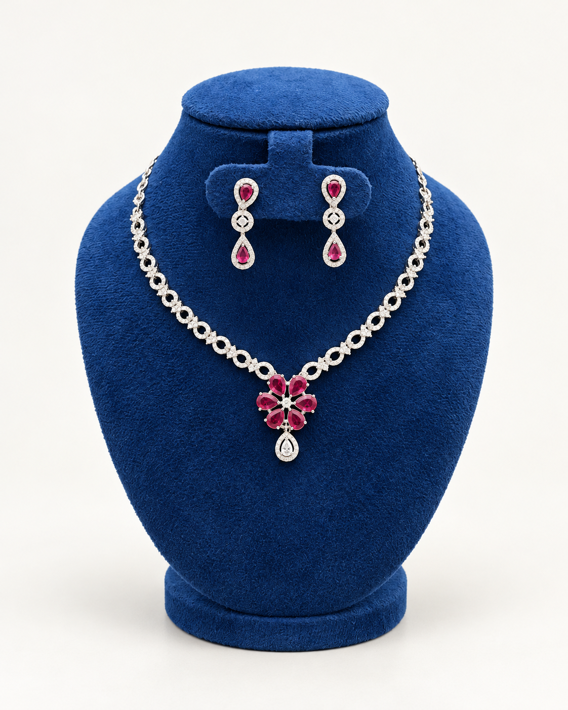 Kaveri floral centre necklace set with drop earrings in maroon on a blue velvet display stand