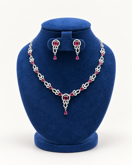 Kaveri leaf garland drop necklace set with earrings in maroon on a blue velvet display stand