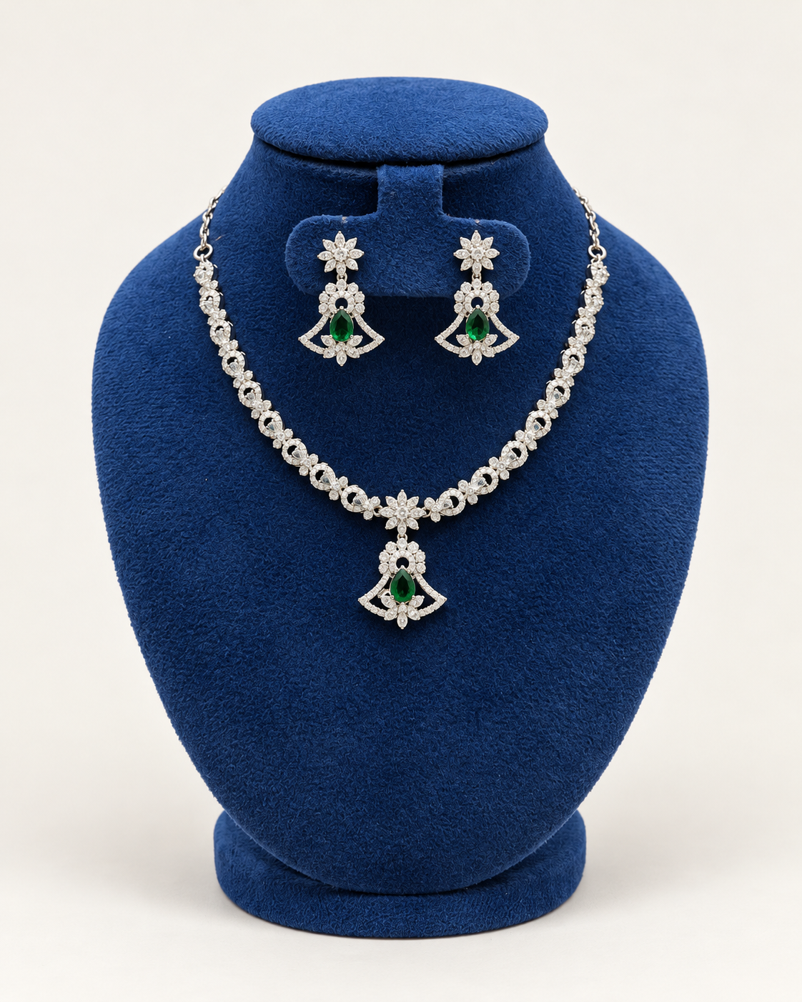 Kaveri fan pendant stone necklace set with earrings in green on a blue velvet display stand
