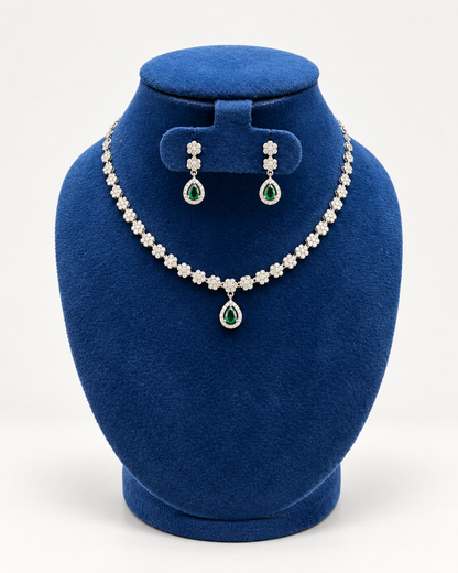 Kaveri flower line teardrop necklace set with earrings in green on a blue velvet display stand
