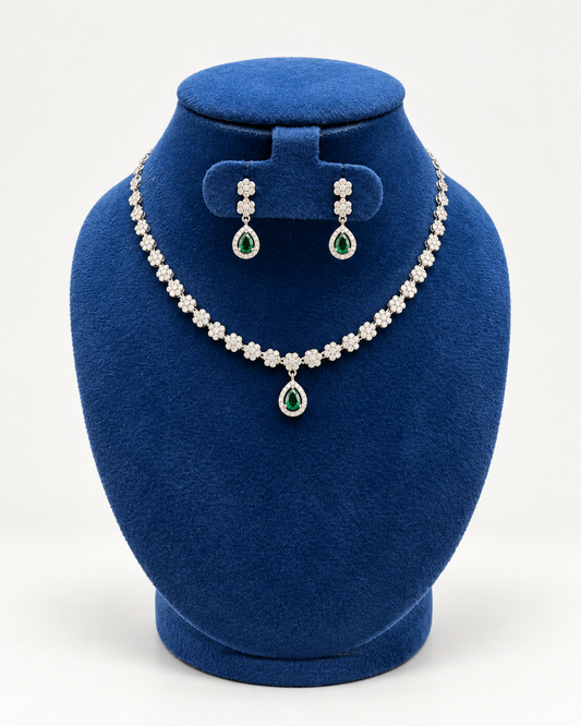 Kaveri flower line teardrop necklace set with earrings in green on a blue velvet display stand