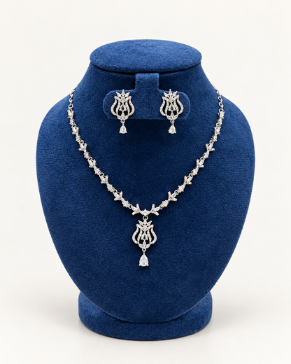 Kaveri ornate scroll pendant necklace set with earrings in clear on a blue velvet display stand