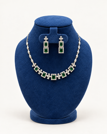 Kaveri square halo necklace set with long earrings in green on a blue velvet display stand